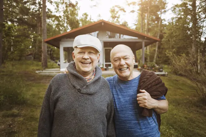 Portrait of happy gay couple standing together at yard