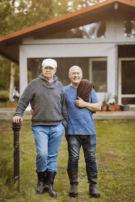 Portrait of happy gay couple standing at yard