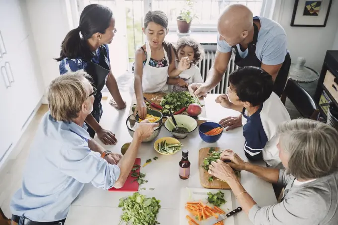 High angle view of family preparing Asian food at table