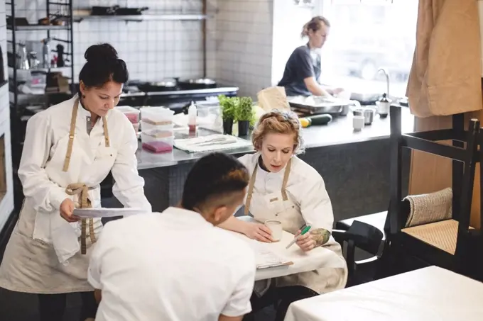 Multi-ethnic restaurant owners discussing while sitting at table