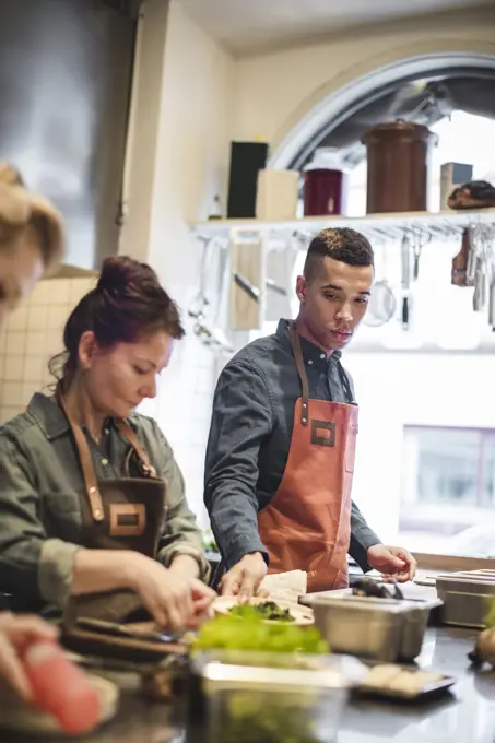 Multi-ethnic chefs cooking food at kitchen counter in restaurant