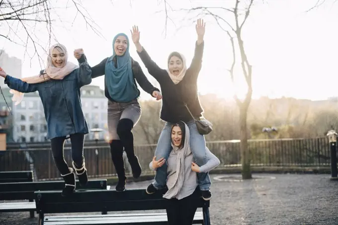 Cheerful multi-ethnic female friends enjoying against clear sky