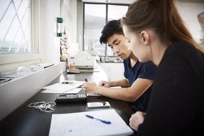 Young multi-ethnic university students studying together in classroom