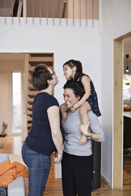 Smiling family enjoying while standing in living room at home