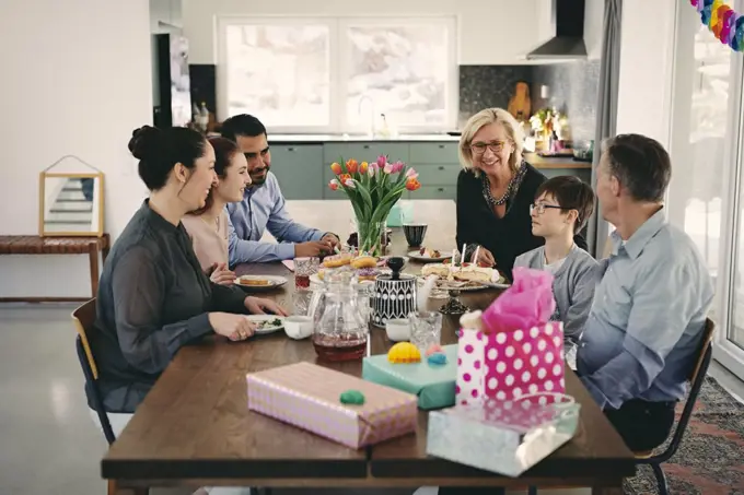 Happy multi-generation family enjoying at table during birthday party