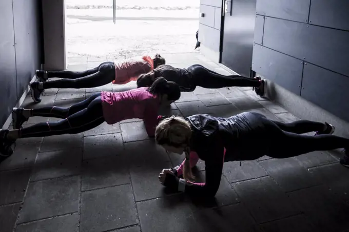 High angle view of women doing plank exercise on footpath during winter