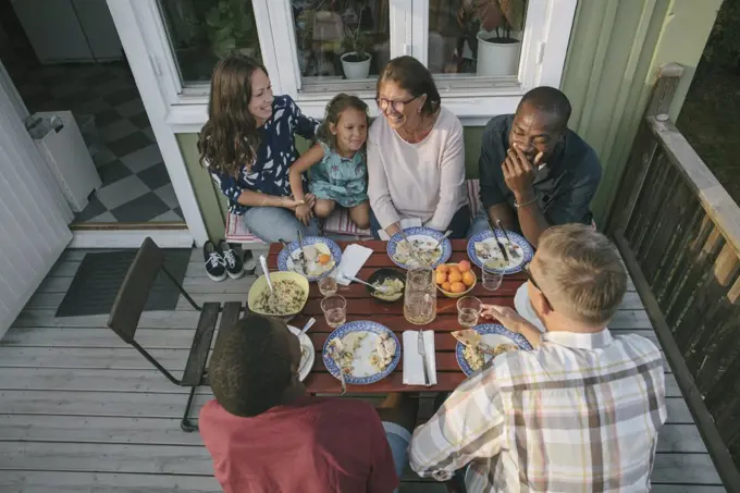 High angle view of multi-generation family having lunch at table on porch