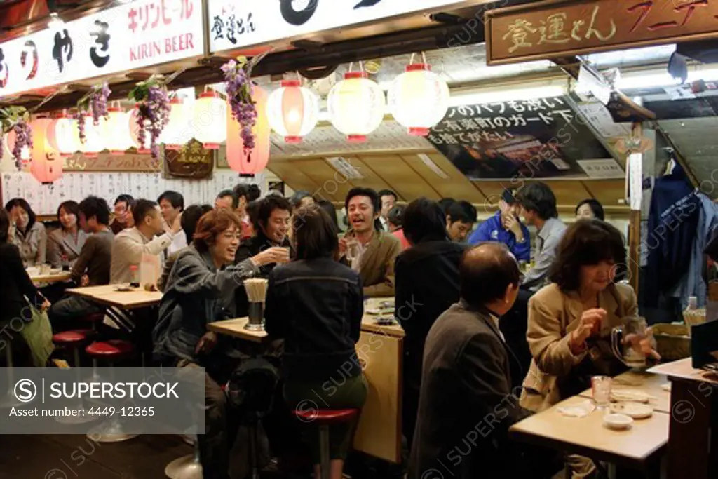 People sitting in a fast food restaurant at night, Yurakucho Yakitori Alley, Ginza, Tokyo, Japan