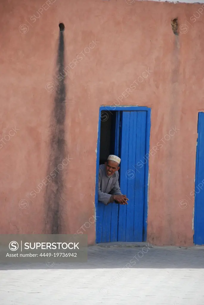 A man look outisde his own in a small town on the way to Agadir