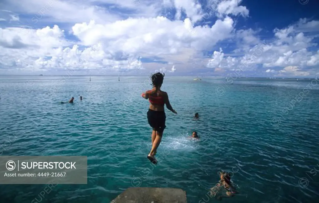 Children jumping into the water at Point Venus, Tahiti, French Polynesia, south sea