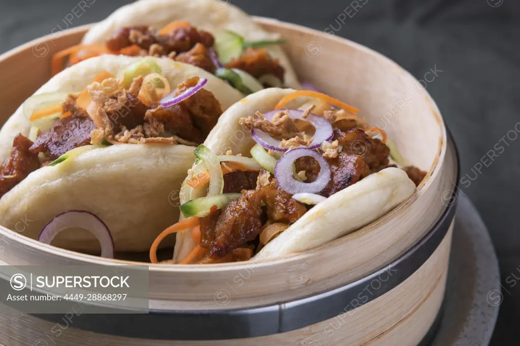 Vegan bao buns with seitan strips in a bamboo basket (Asia)