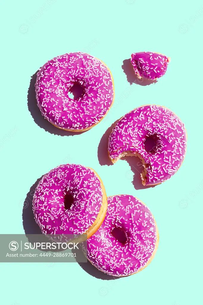 Donuts with pink icing on turquoise background