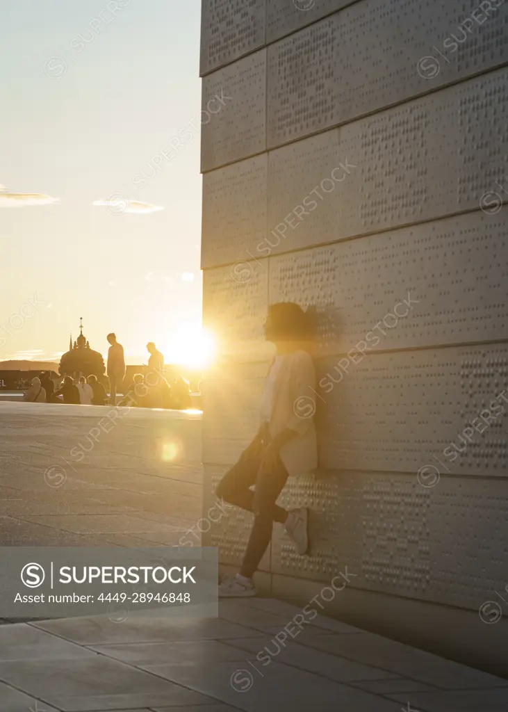 Tourist watching sunset on the roof of the Opera House in Oslo, Norway.