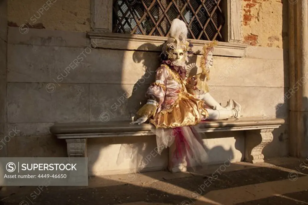 A woman in the carnival costume sitting on the bench, Venice, Italy