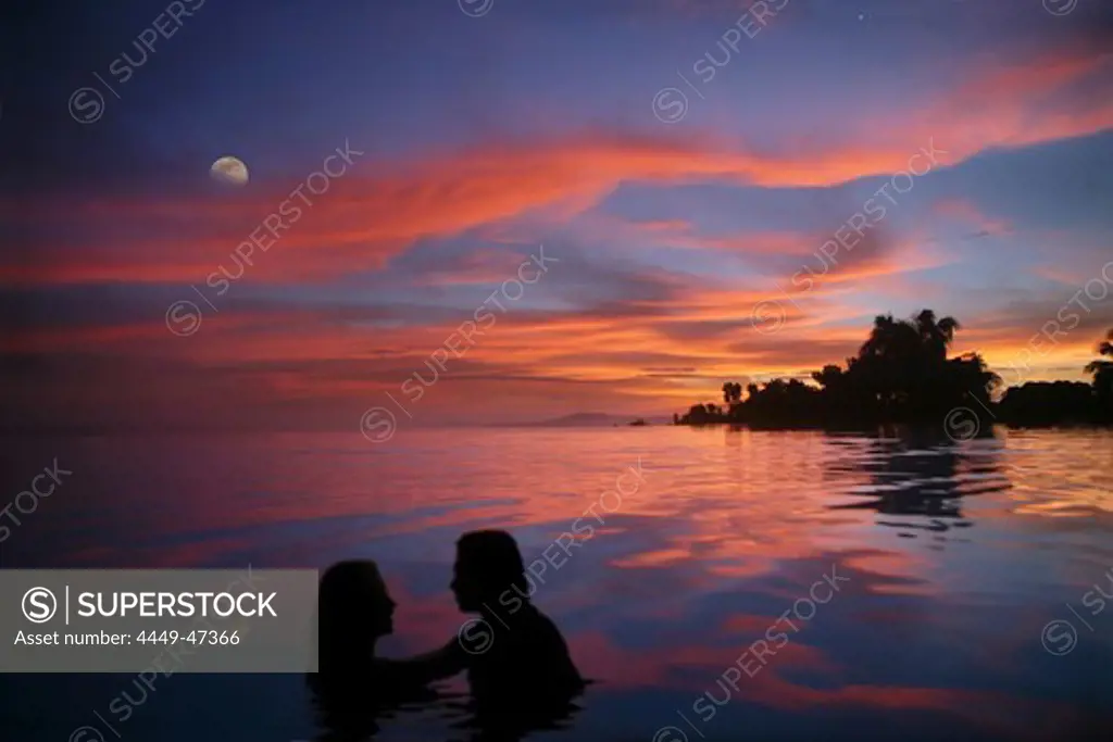 A couple in an infinity pool at sunset, Bohol Island, Philippines, Asia