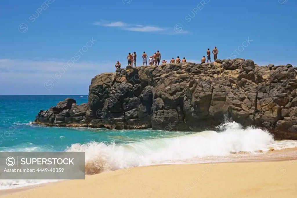 People on a rock at the beach, Weimea Bay Beach Park, North Shore, Oahu, Hawaii, USA, America