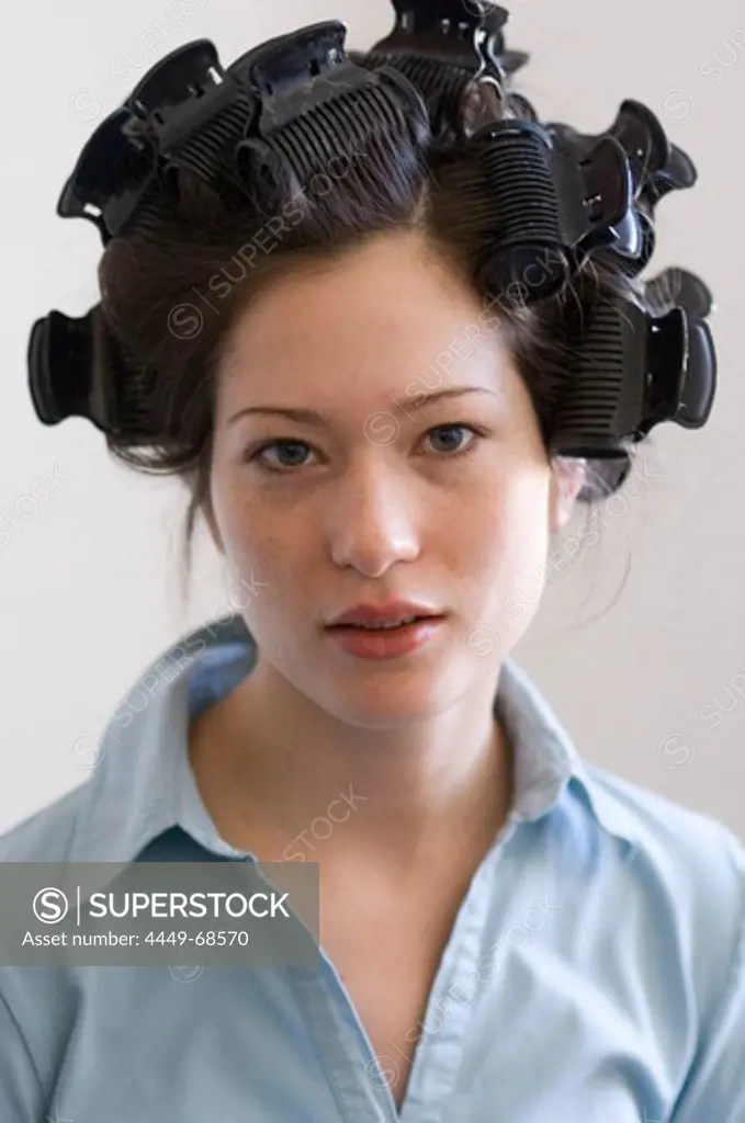 Young woman with curlers in hair, portrait