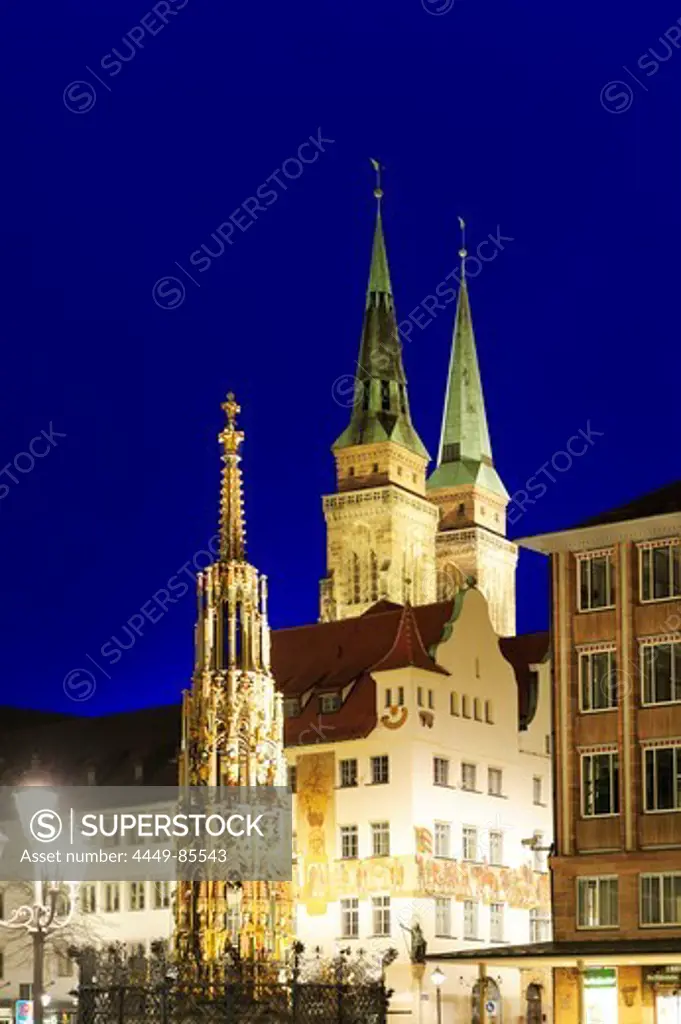 Illuminated fountain Schoener Brunnen on the market square and St. Sebaldus church at night, Nuremberg, Bavaria, Germany