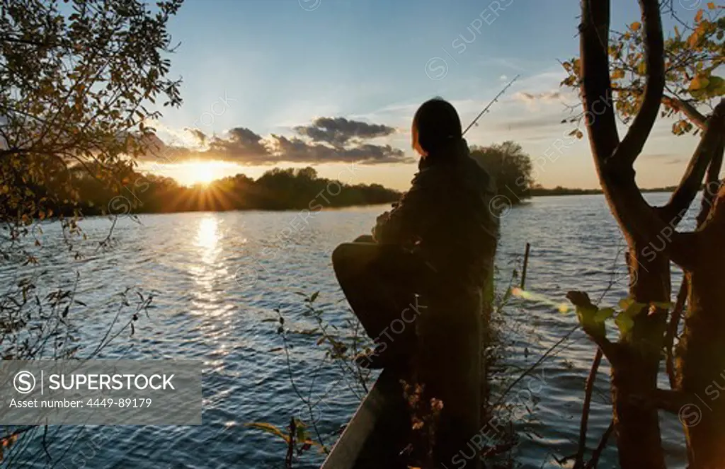 Boy fishing on the border between the Sacrow Paretz Canal the Fahrlander See, Neu Fahrland, near Potsdam, Brandenburg, Germany