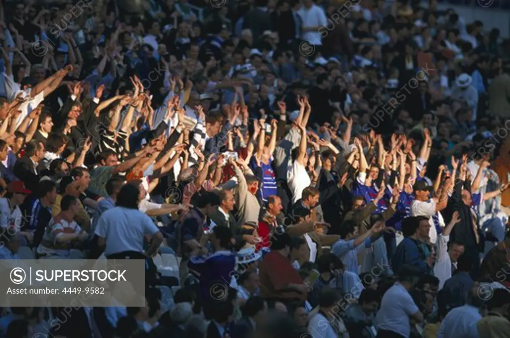 Fans at the football stadium stretching up their arms