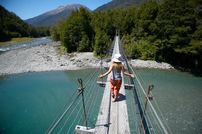 Girl on hanging bridge, track to Blue Pools, east of Haast Pass, Southern Alps, South Island, New Zealand