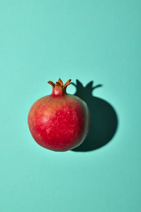 Pomegranate on turquoise background