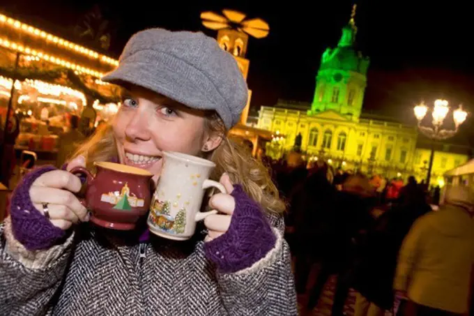 Girl enjoying mulled wine at the Christmas market at Schloss Charlottenburg, Berlin, Germany