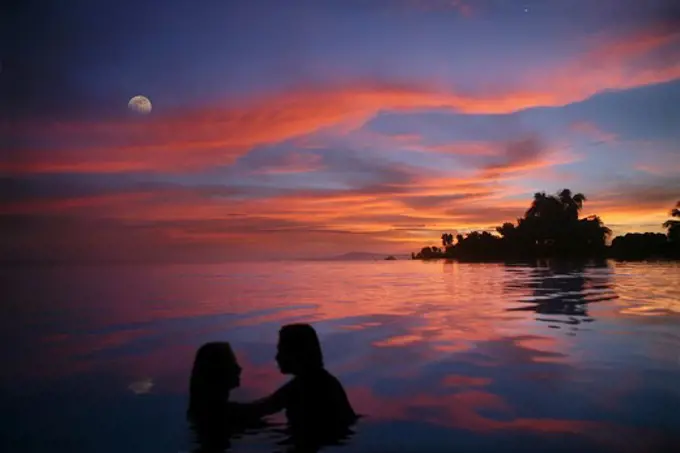 A couple in an infinity pool at sunset, Bohol Island, Philippines, Asia