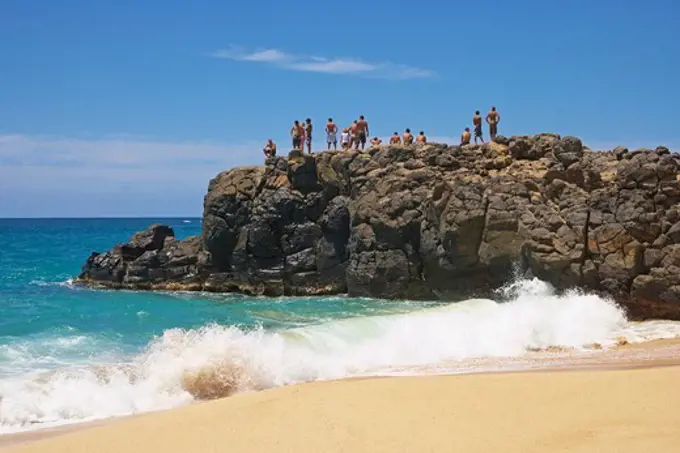 People on a rock at the beach, Weimea Bay Beach Park, North Shore, Oahu, Hawaii, USA, America