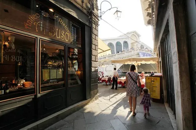 Mother and daughter walking down an alleyway near the Rialto bridge, Venice, Veneto, Italy