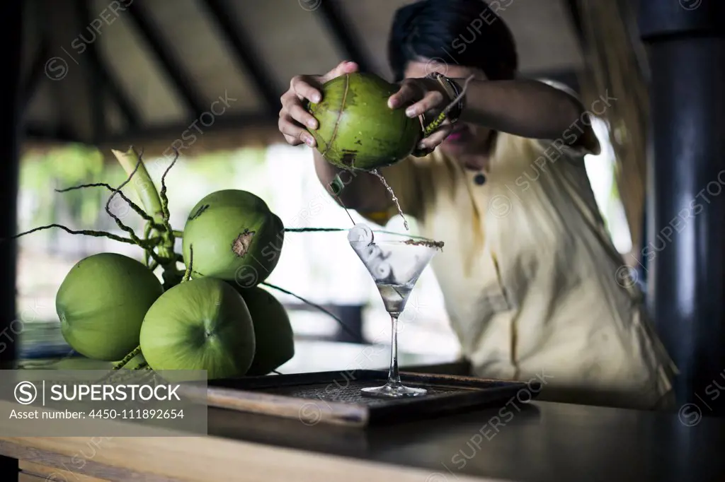 A bartender mixing a martini (Praow-Tini) out of a coconut shaker.