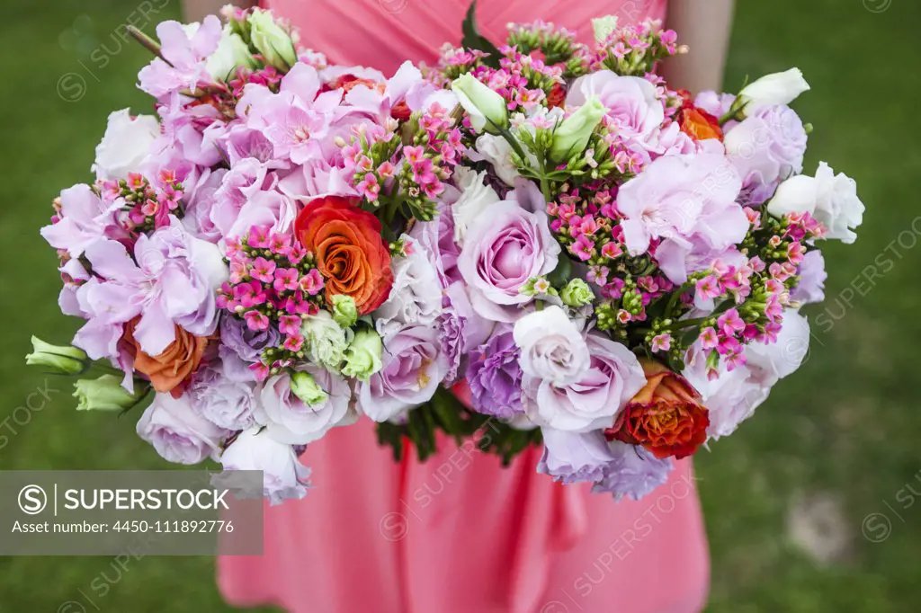 High angle close up of woman holding two bouquets of flowers with pink roses.