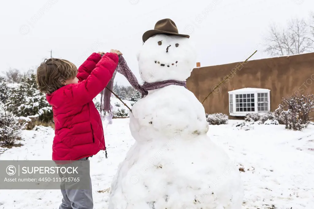 A young boy building a snowman