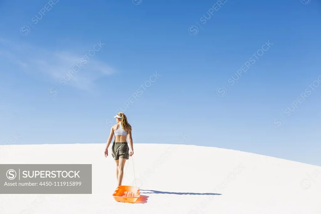 A teenage girl pulling a sled