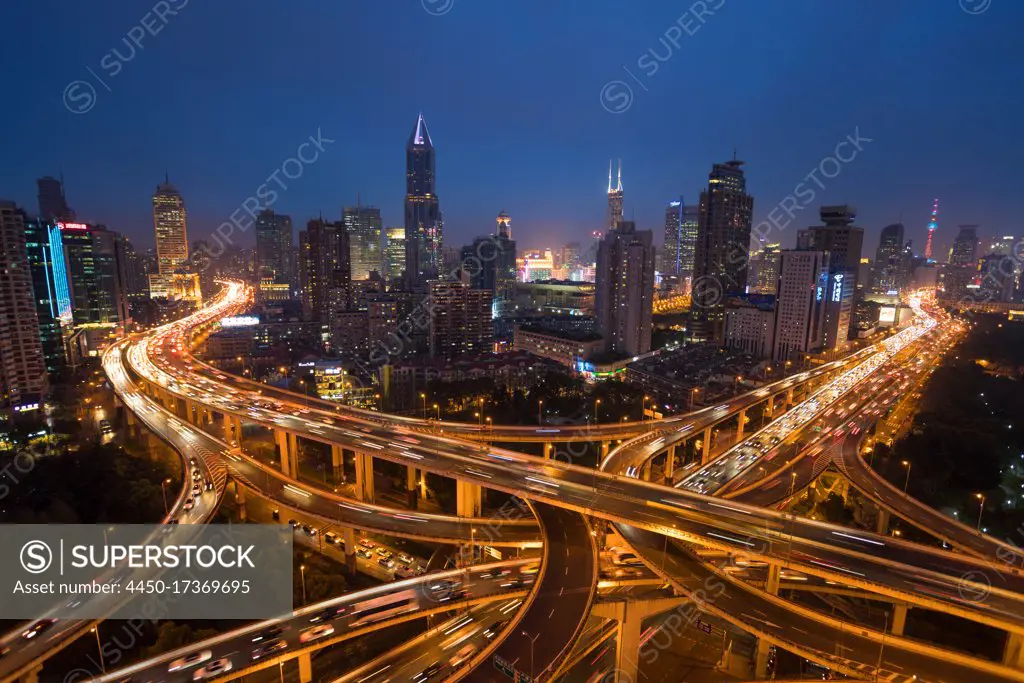 Elevated road junction and skyline of Shanghai, China at dusk.