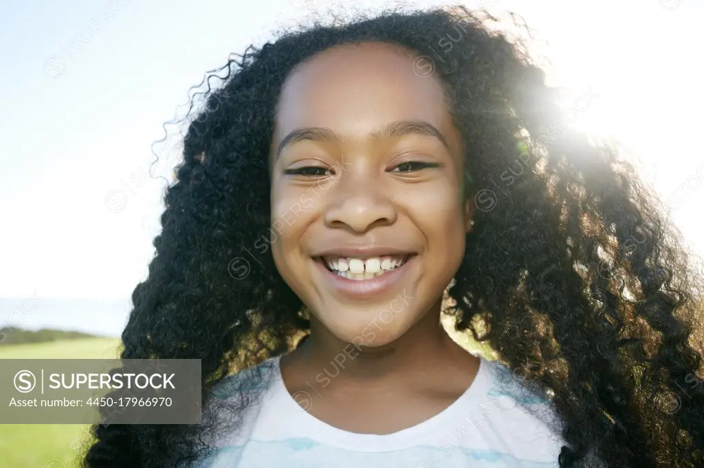 Young mixed race girl with long curly black hair, smiling