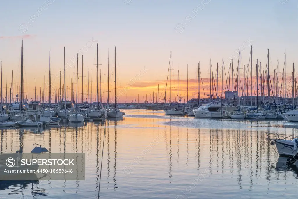 Boats moored in the harbour marina in Palermo at sunrise.