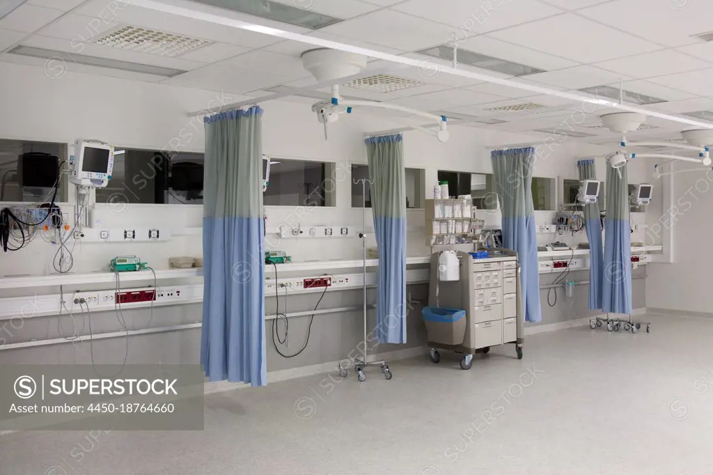 Recovery room outside the operating theatre in a hospital. Drapes, blue curtains around patient bays