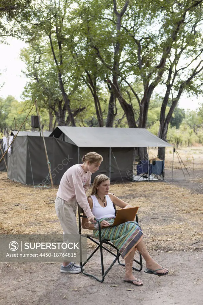 adult woman using laptop, tented camp, Okavango Delta, Botswana