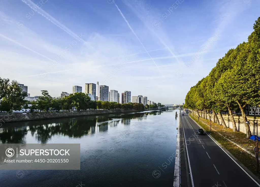 View along the River Seine, a road by the water, high rise buildings. 