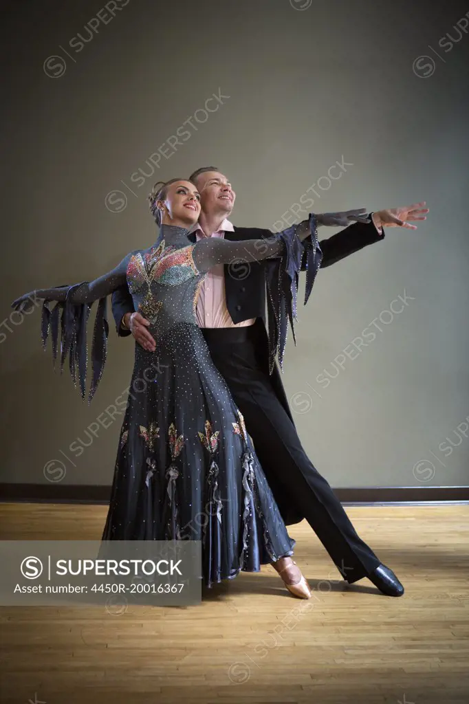 A man and woman dancing together in a dance studio.