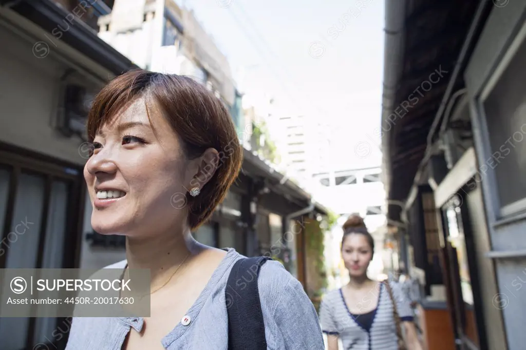 Two women standing outdoors, smiling.