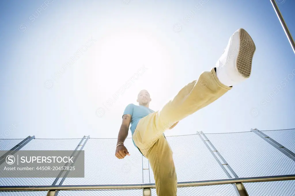 Young man somersaulting on a bridge.