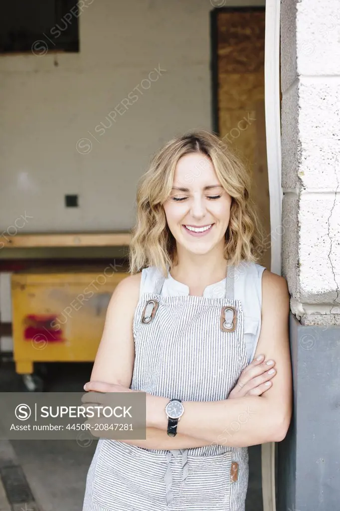 A business owner and craftsman standing in the doorway of her workshop.