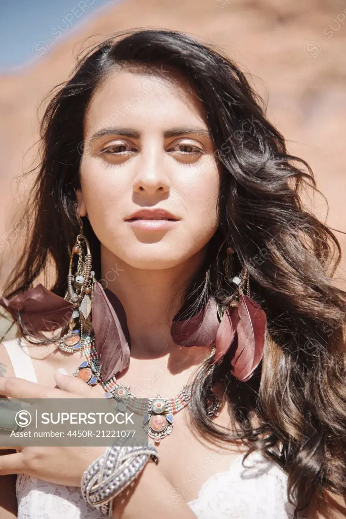 Portrait of a young woman with long brown hair. Hair blowing in the wind.