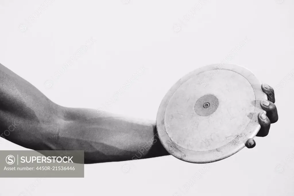 A female track and field athlete holding a discus in her hand.