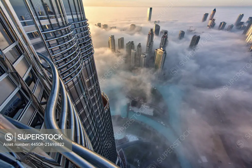 Aerial view of cityscape with skyscrapers above the clouds in Dubai, United Arab Emirates.