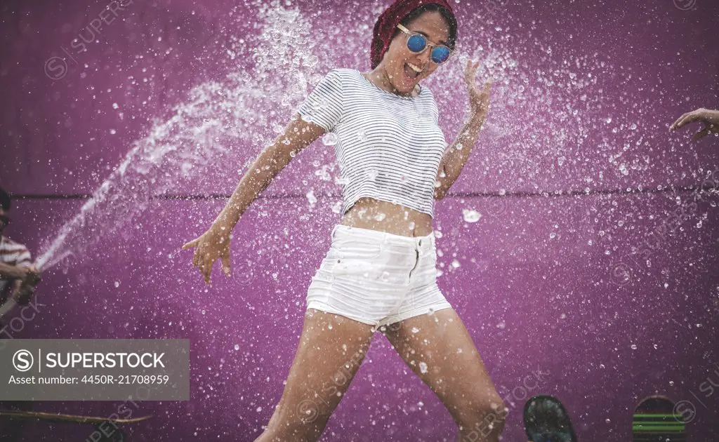 A young woman being sprayed with water.