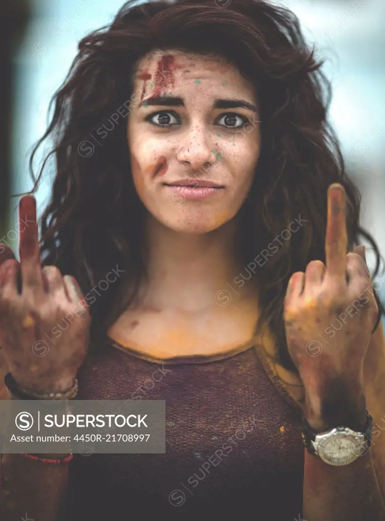 Young woman holding up two fingers in a hand gesture to the camera.