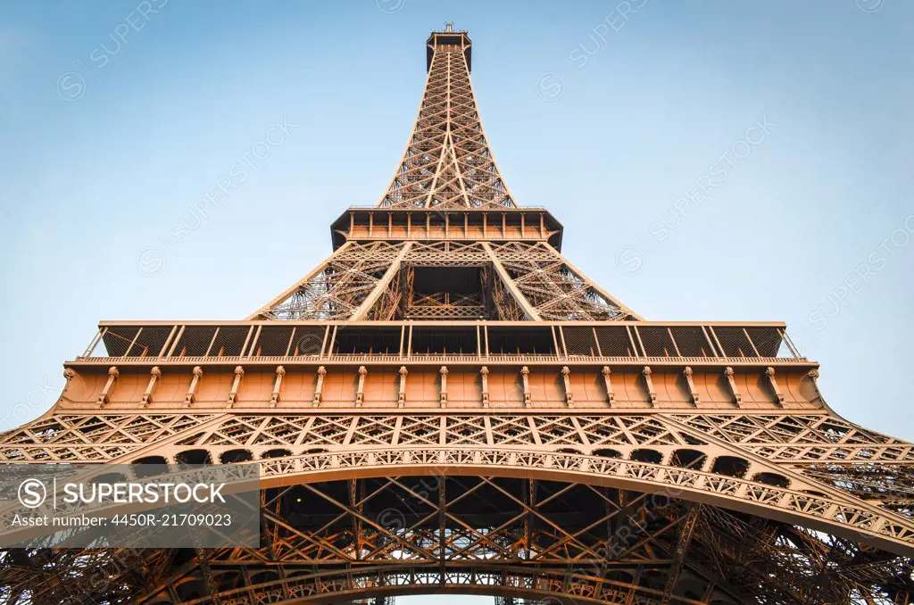 Low angle view of the Eiffel Tower in Paris,  Champs de Mars against a blue sky.